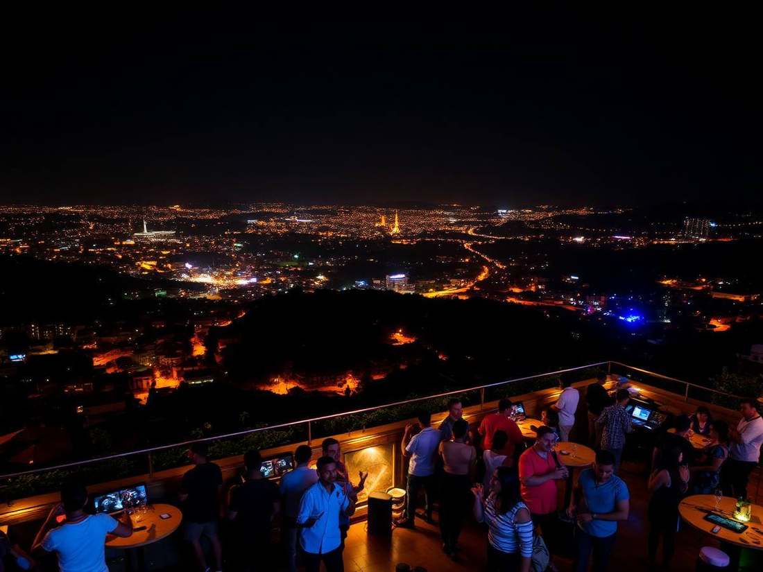A Kigali rooftop at night with city lights spreading across the hills