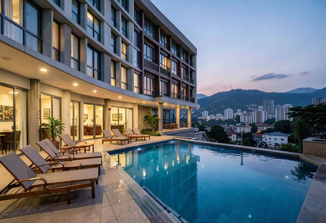 Pool deck of a full-service Kigali hotel at dusk with the hills behind
