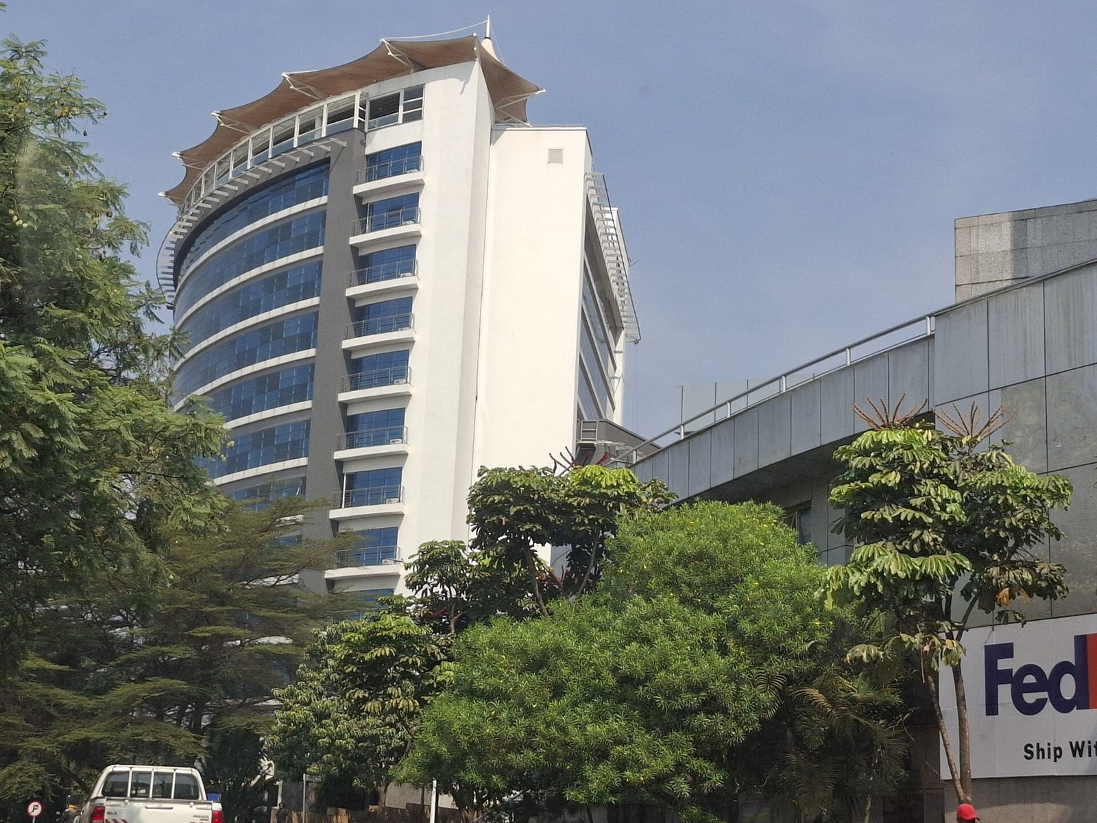 Visitors walking a tree-lined Kigali boulevard